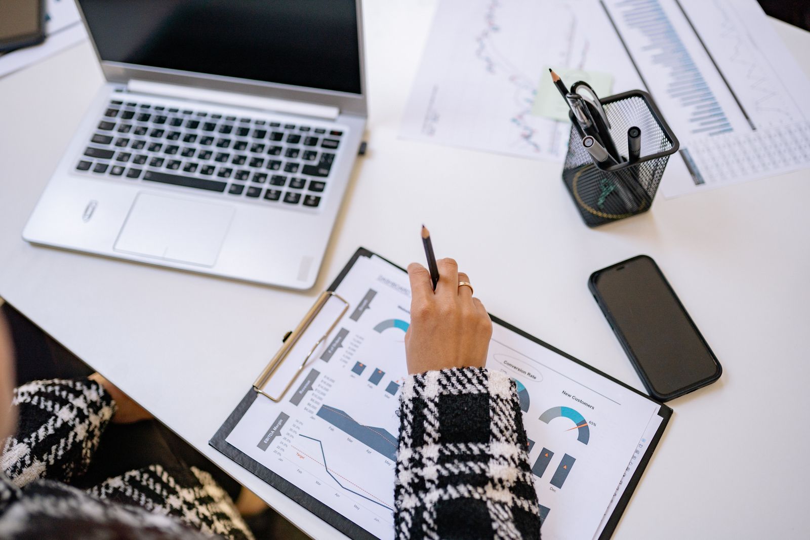 Top-down view of SaaS metrics and charts analyzed beside a laptop, the coverage proxies lenders use instead of classic DSCR