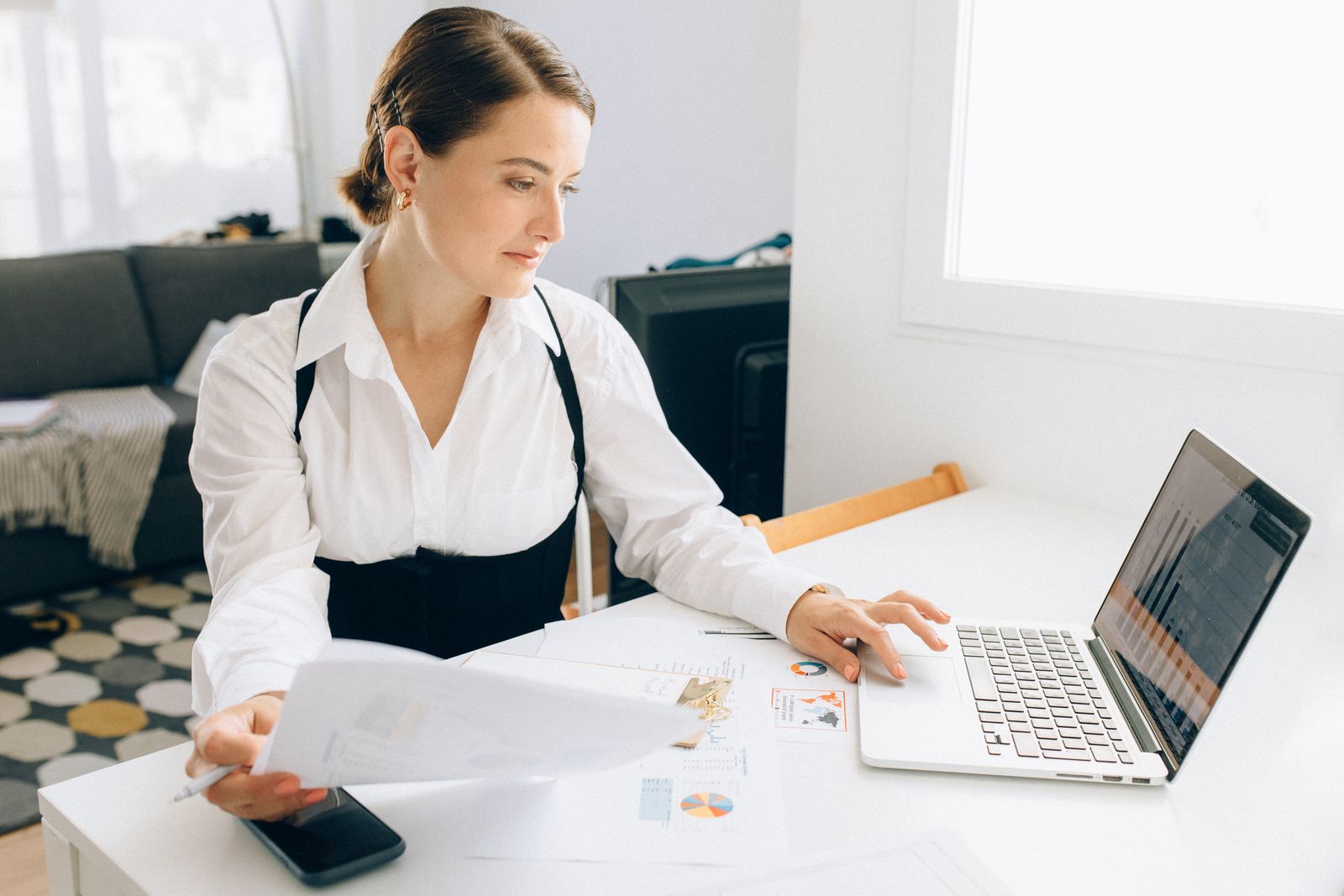 A founder reviewing financial reports on a laptop to weigh revenue-based financing