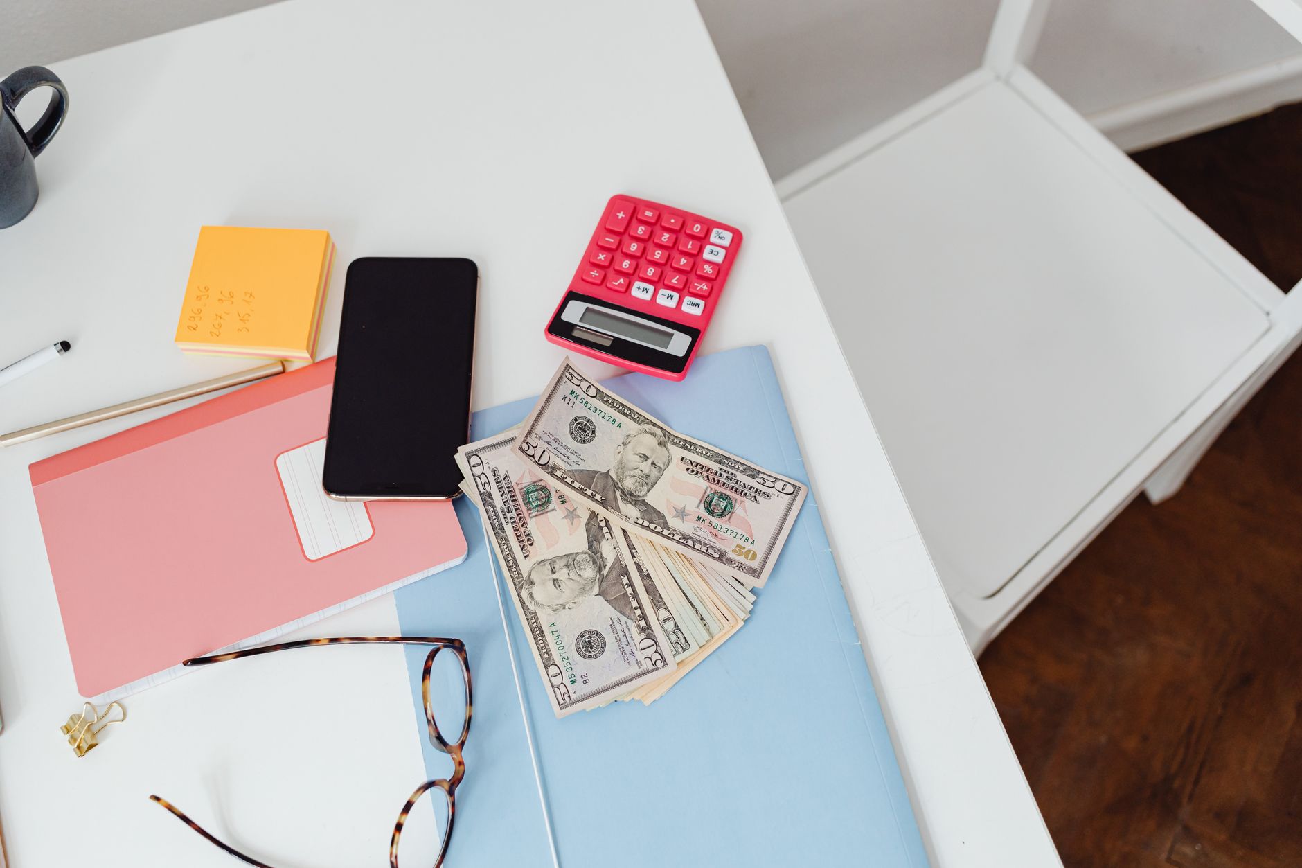 A calculator and cash with working notes, the kind of math behind a SaaS pricing strategy