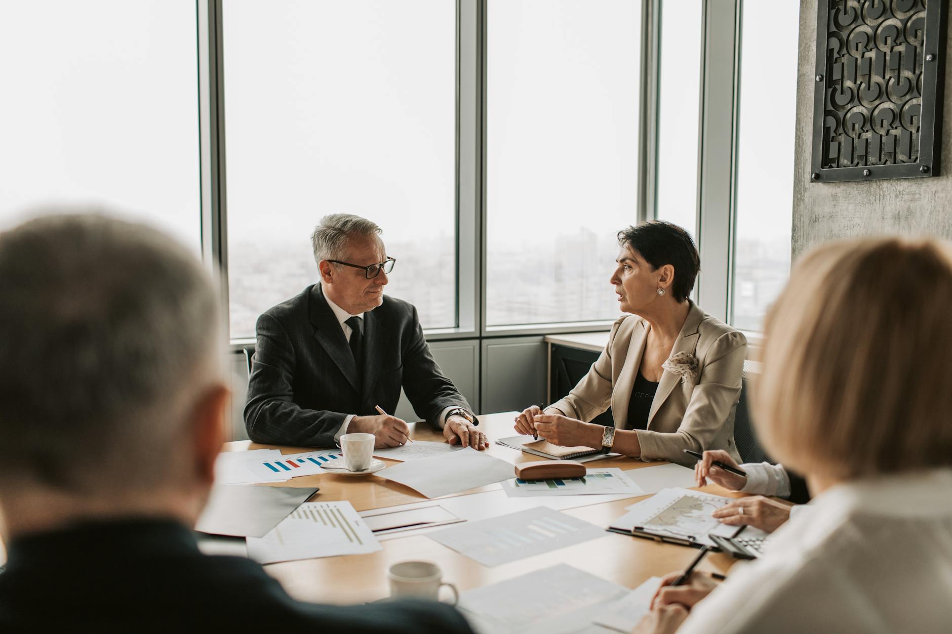 Investors and fund managers in a boardroom where fund-of-funds allocation decisions are made