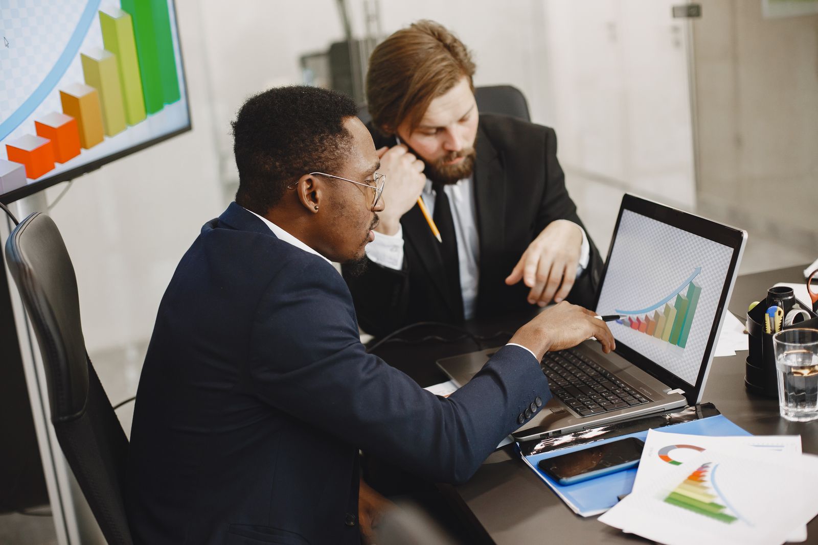 Two startup founders reviewing growth and cash flow projections on a laptop screen